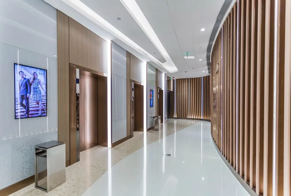 Commercial passenger lifts in a timber-lined lobby